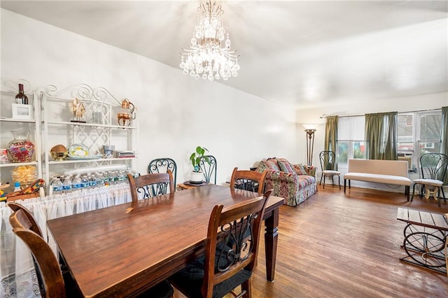 dining area featuring wood-type flooring and an inviting chandelier