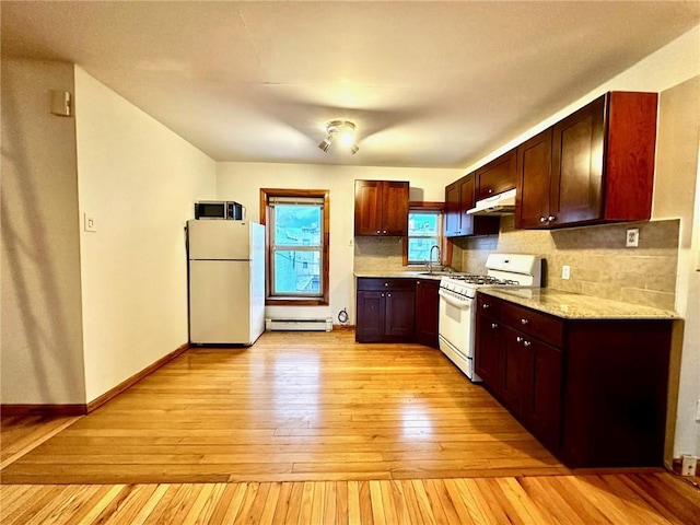 kitchen with white appliances, sink, light hardwood / wood-style flooring, decorative backsplash, and a baseboard radiator