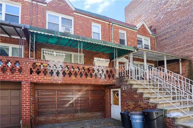 multi unit property featuring a garage and brick siding