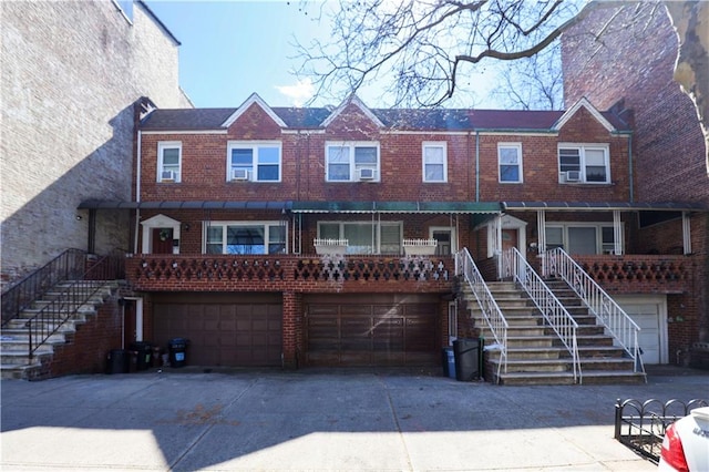268 73rd St, Brooklyn, NY 11209 - view of property with brick siding, an attached garage, concrete driveway, and stairs