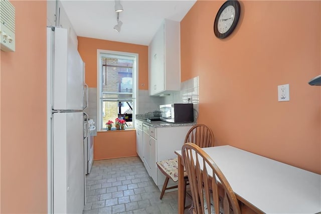 kitchen featuring white cabinets and white appliances