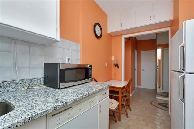 kitchen featuring white cabinets, white appliances, tasteful backsplash, and light stone counters