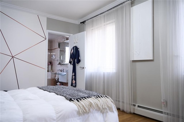 bedroom featuring ornamental molding, a baseboard radiator, and hardwood / wood-style floors