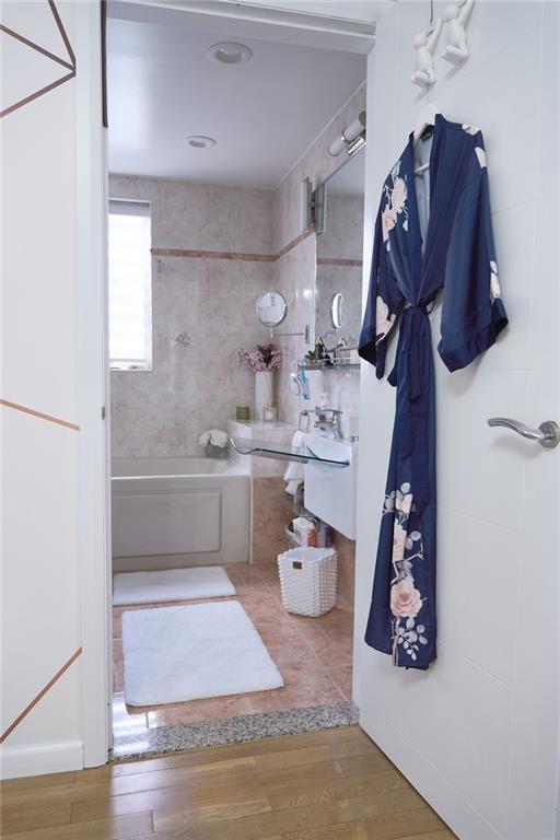 bathroom with tiled shower / bath and hardwood / wood-style flooring