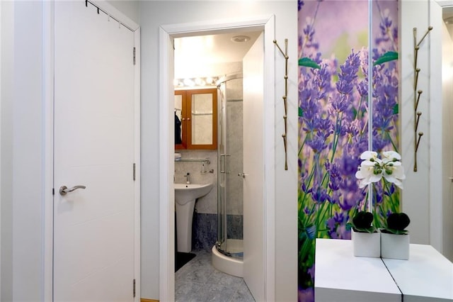 bathroom with walk in shower, sink, and tile patterned flooring