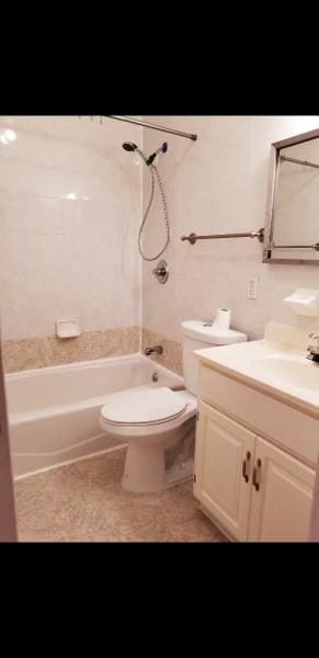 full bathroom featuring toilet, tiled shower / bath, and vanity