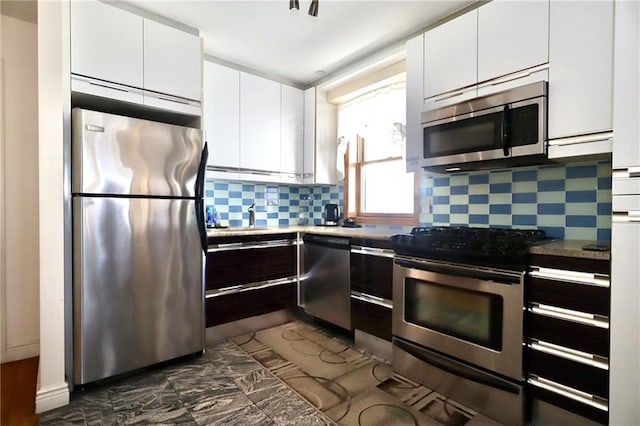 kitchen with white cabinets, sink, backsplash, and appliances with stainless steel finishes