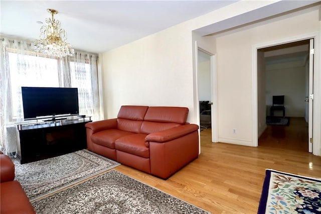 living room with a notable chandelier and light wood-type flooring