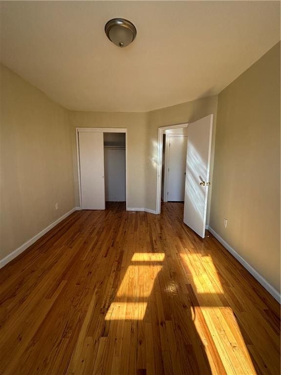 unfurnished bedroom with hardwood / wood-style flooring and a closet