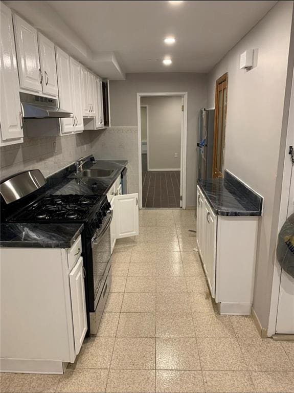 kitchen featuring backsplash, appliances with stainless steel finishes, sink, and white cabinets