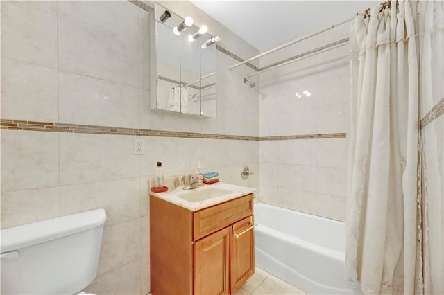 full bathroom featuring vanity, shower / bath combination with curtain, tile patterned flooring, toilet, and tile walls