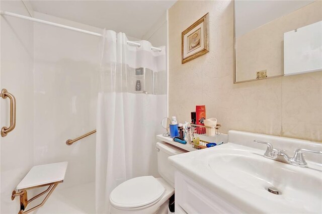 bathroom featuring sink, curtained shower, and toilet