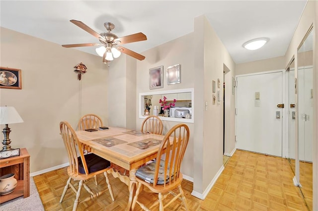 dining area with ceiling fan and light parquet floors