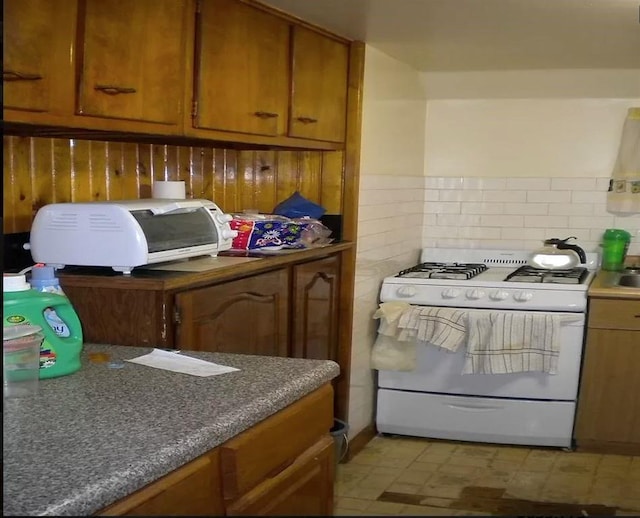 kitchen with tasteful backsplash and white range with gas cooktop