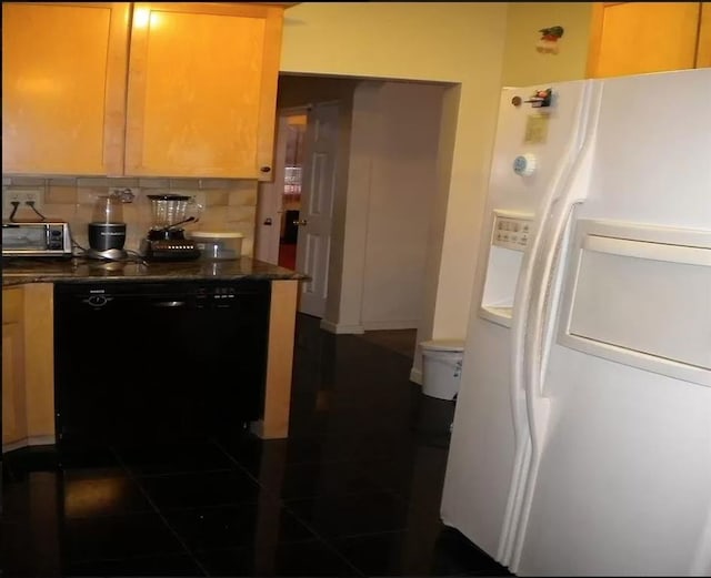 kitchen with white refrigerator with ice dispenser, decorative backsplash, black dishwasher, and dark tile patterned flooring