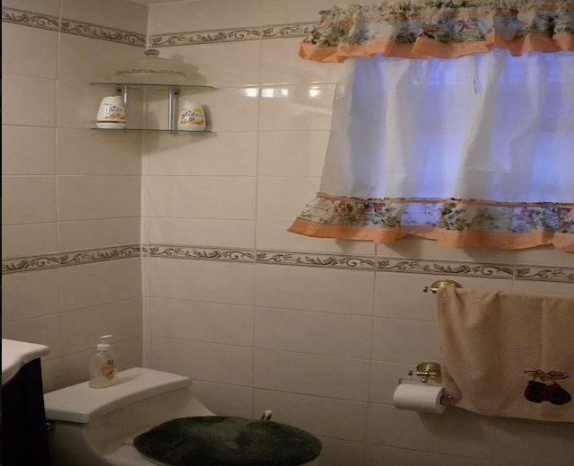 bathroom with vanity, toilet, and tile walls