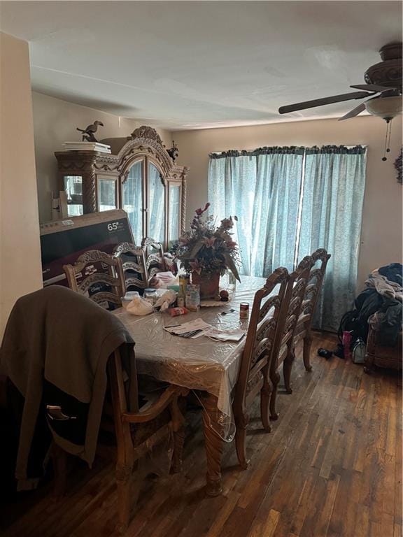 dining space with ceiling fan and dark wood-type flooring