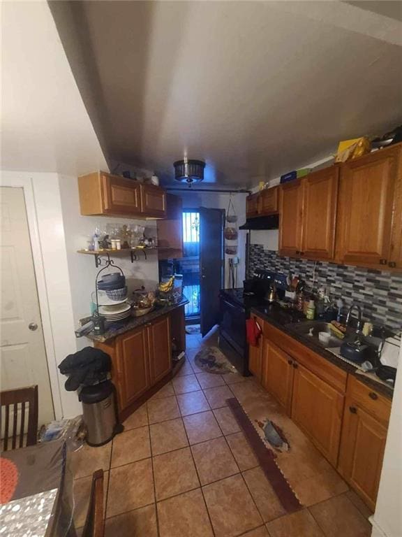 kitchen with tasteful backsplash, black stove, and light tile patterned floors