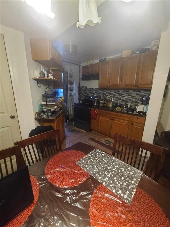 kitchen with backsplash, electric range, sink, and light tile patterned flooring