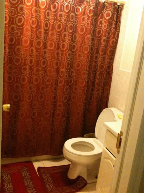 bathroom featuring tile patterned flooring, vanity, and toilet