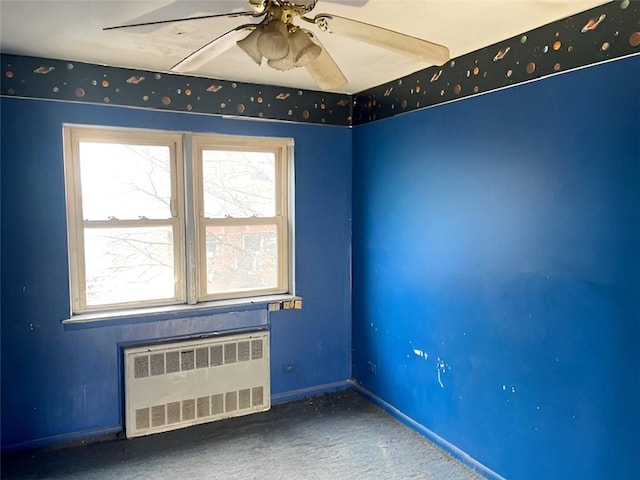 carpeted spare room featuring ceiling fan and radiator heating unit