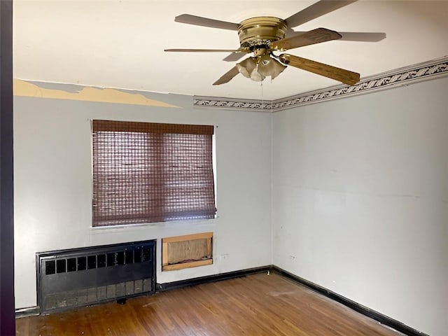 unfurnished room with hardwood / wood-style flooring, radiator heating unit, and ceiling fan