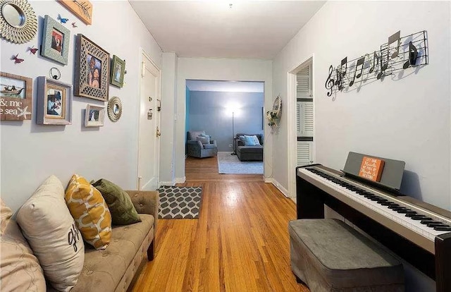 hallway featuring light wood-style flooring and baseboards