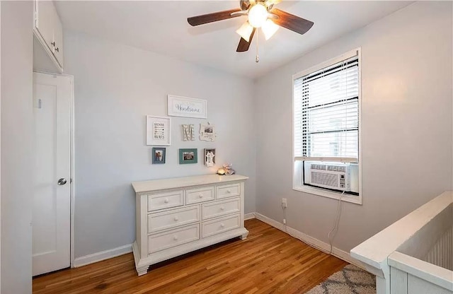 bedroom with ceiling fan, cooling unit, baseboards, and light wood-style floors