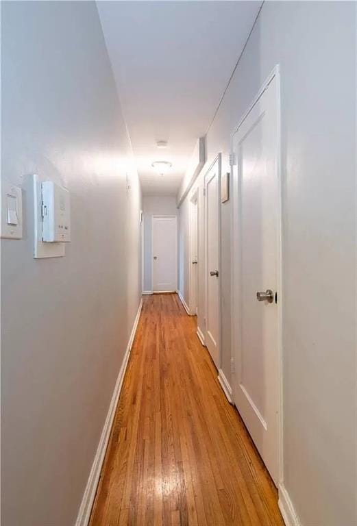 hall featuring baseboards and light wood finished floors