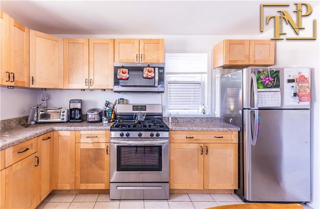 kitchen featuring stainless steel appliances, a toaster, light tile patterned flooring, and light brown cabinetry