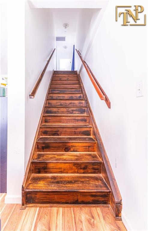 stairs featuring hardwood / wood-style floors