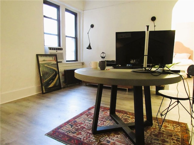 office area featuring cooling unit, radiator, and hardwood / wood-style floors