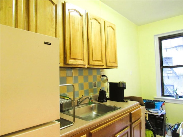 kitchen featuring white fridge, sink, and decorative backsplash