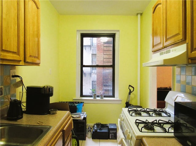 kitchen with white gas range and backsplash