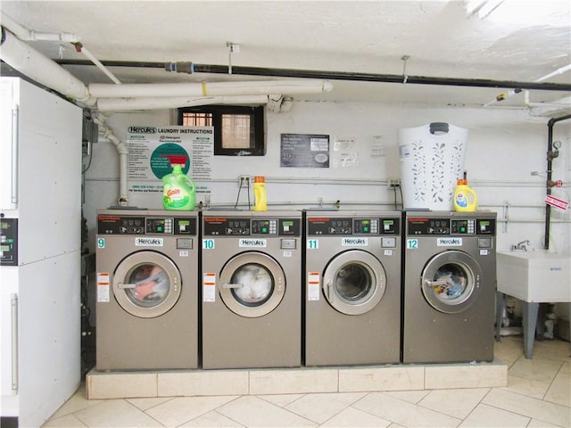 washroom with separate washer and dryer, light tile patterned floors, and sink