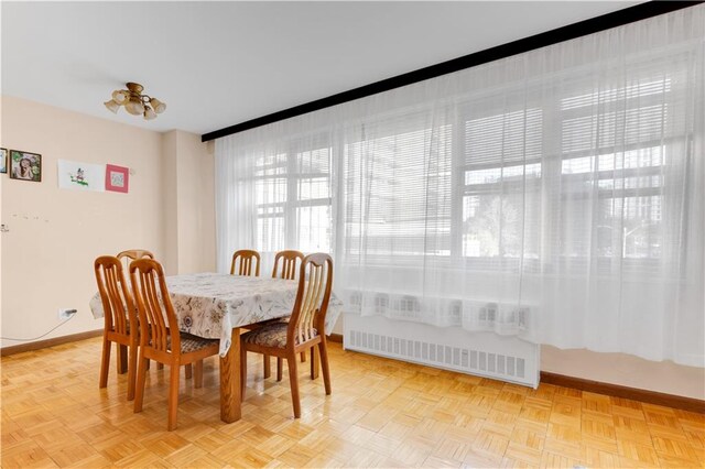 dining area featuring parquet floors and radiator