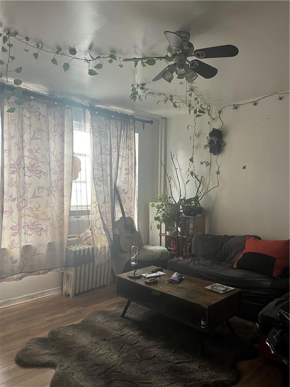 living room with wood finished floors and a ceiling fan