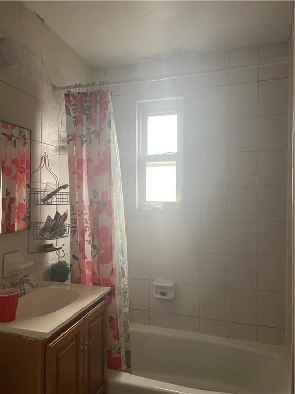 bathroom featuring vanity and shower / bathtub combination with curtain