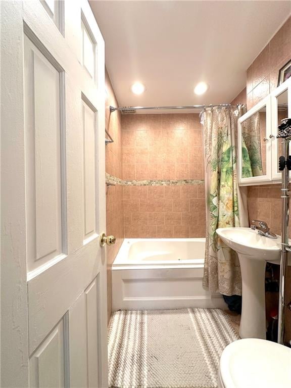 bathroom with tasteful backsplash, shower / bath combination with curtain, and toilet