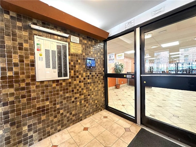 entryway featuring light tile patterned floors, a paneled ceiling, and visible vents