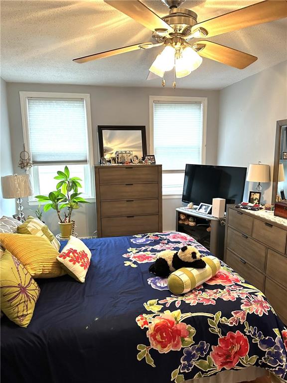 bedroom with a textured ceiling and ceiling fan