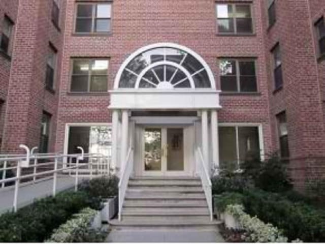 entrance to property featuring brick siding