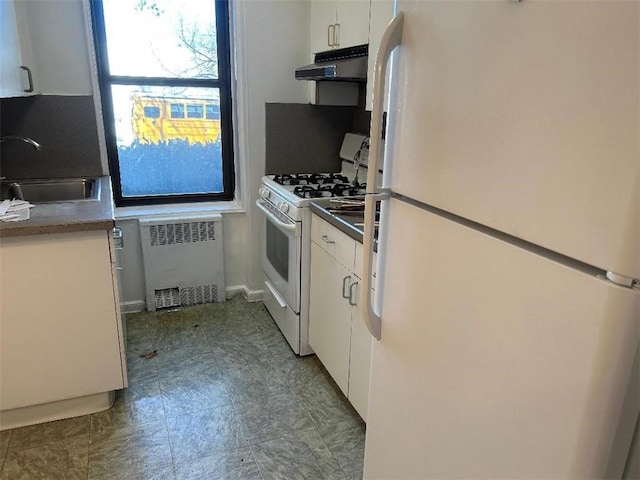 kitchen with radiator heating unit, range hood, sink, white appliances, and tile floors