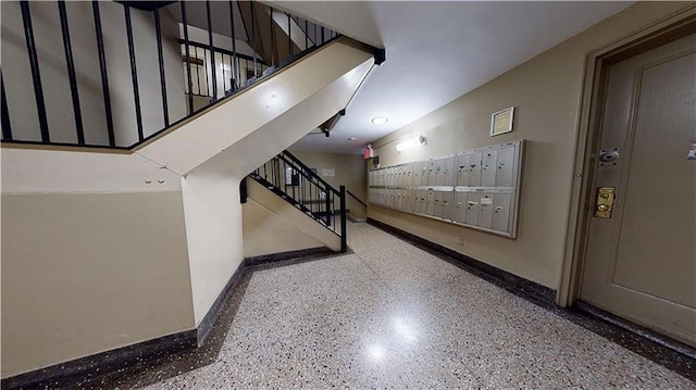 interior space featuring mail area, speckled floor, and baseboards