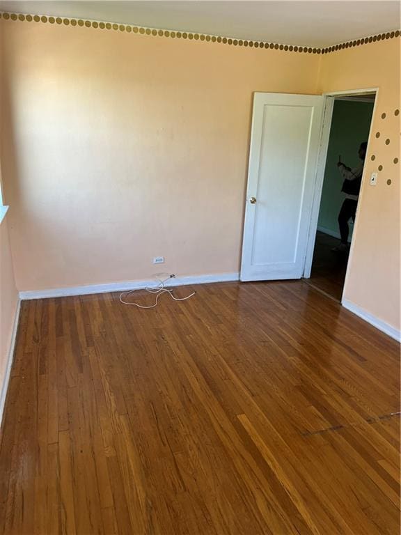 spare room with wood finished floors and baseboards