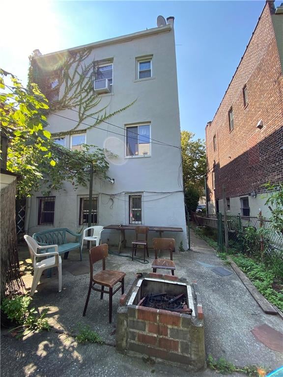 rear view of house featuring a patio area and an outdoor living space with a fire pit