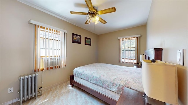 bedroom with ceiling fan, radiator, and multiple windows