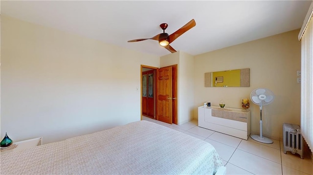 tiled bedroom featuring ceiling fan and radiator heating unit