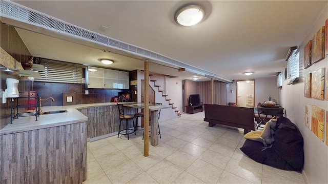 kitchen with kitchen peninsula, backsplash, and sink