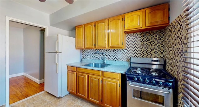1934 Haring St, Brooklyn, NY 11229 - kitchen featuring a sink, stainless steel range with gas stovetop, light countertops, freestanding refrigerator, and decorative backsplash